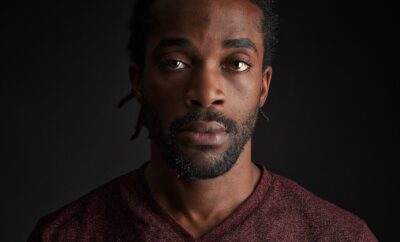 man wearing red v-neck shirt close-up photography